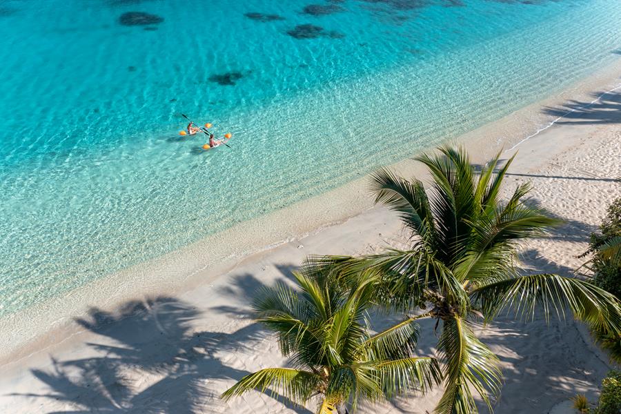 Guests kayaking along the beach at Kokomo Private Island Fiji