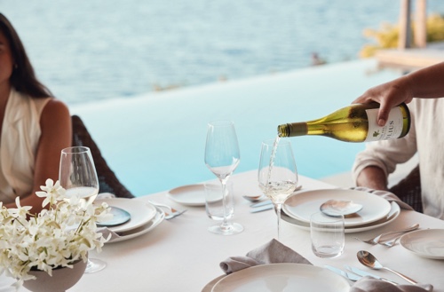 One of the waiters pouring white into a glass for a guest.